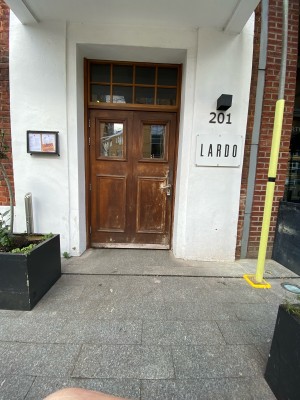 Wooden door with glass panels ahead. Push down handle on right to open.