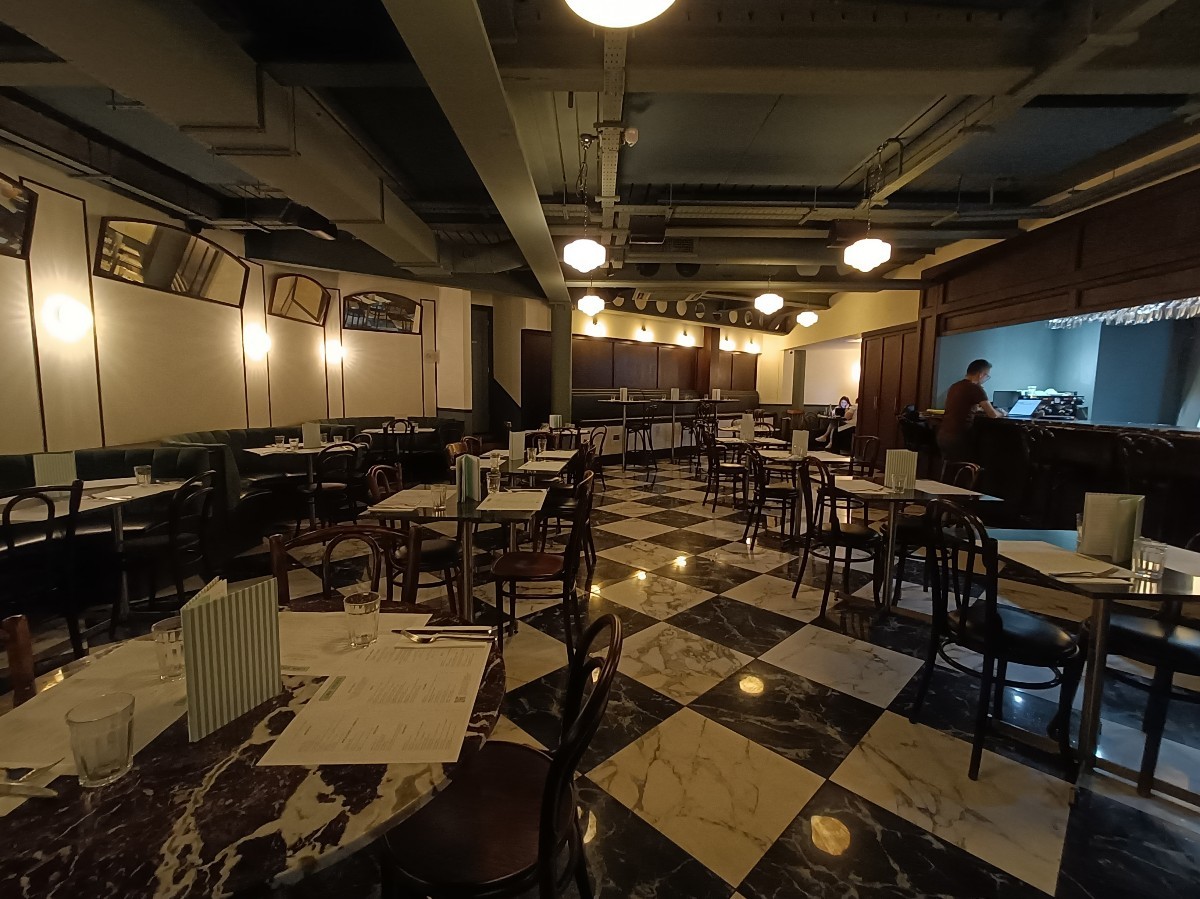 From host desk, looking left. Tables and chairs on both sides. Path in middle.