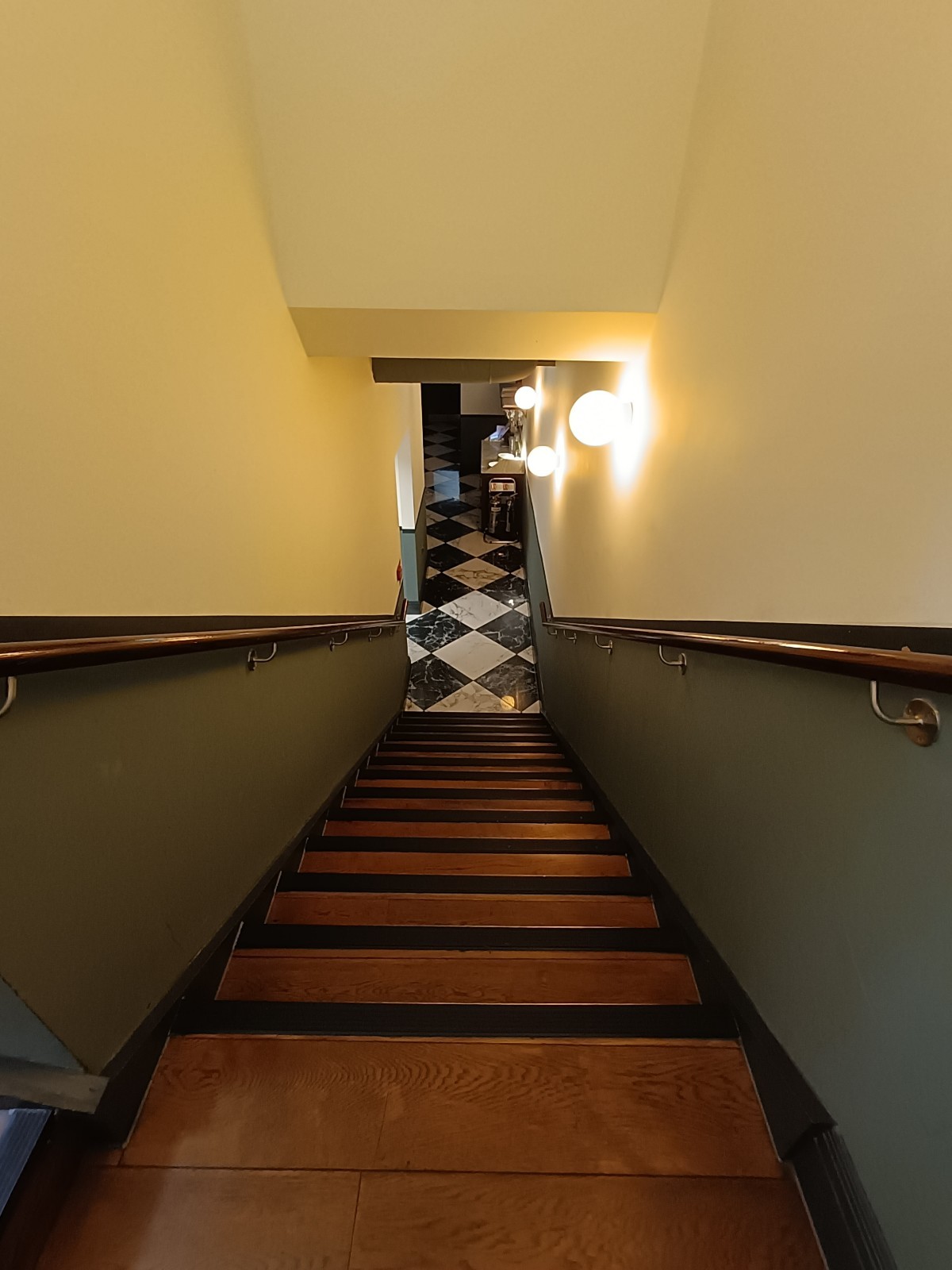 From landing, looking left. Stairs ahead. Handrails on both sides.