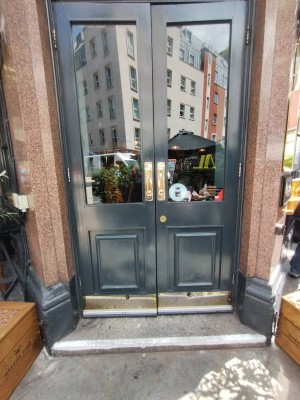 Glass doors with green frame. Golden handle in middle. Push to open.
