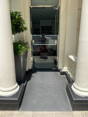Built in ramp leading up to single door. Door pushes open via a handrail along centre of the door.