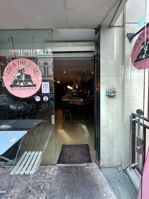 Glass door ahead. Pull via vertical metal handle on right to open.