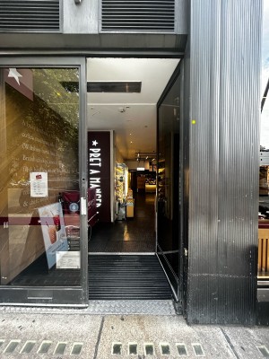 Single glass door with iron handle on mid left. Push to open.