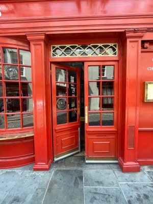 Glass doors with red frame. Golden pad in the centre. Push to open.