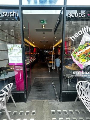Glass door with silver vertical handle on left. Push to open.