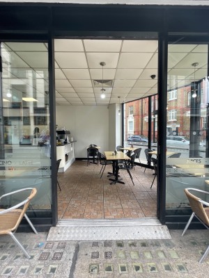 Glass doors with black frame ahead. Slide from centre to open.