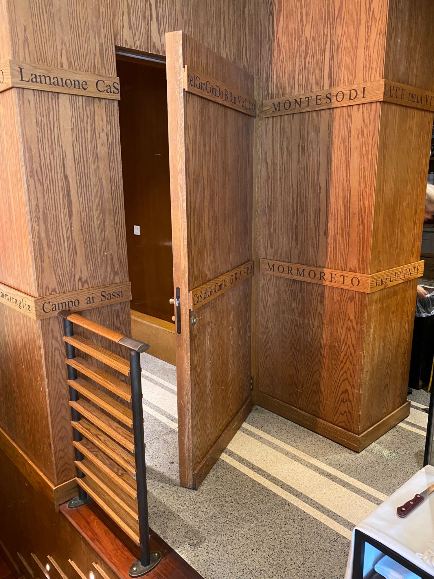In between staircase barricade & table. Bathroom door on left after you go through.