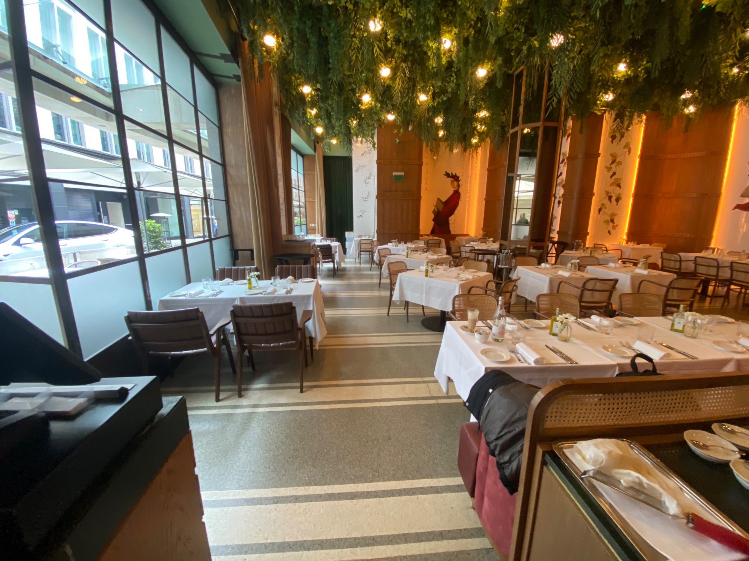 Go down pathway past check in counter, turn left. Tables & chairs along left wall & in middle on right. In front on right are half booths. Pathway in middle.