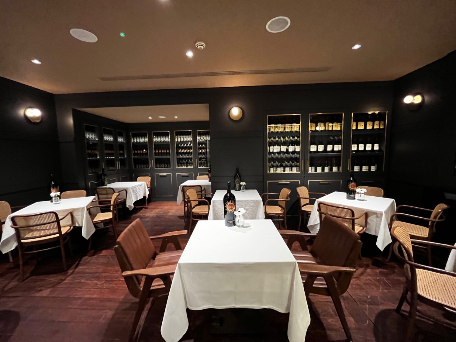 Quiet dining area from doorway. Tables and chairs throughout area.