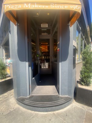 Entrance straight ahead. One step before first glass door. Push.