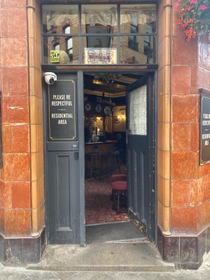 Access via wooden grey door. Push open via metal pad on left.