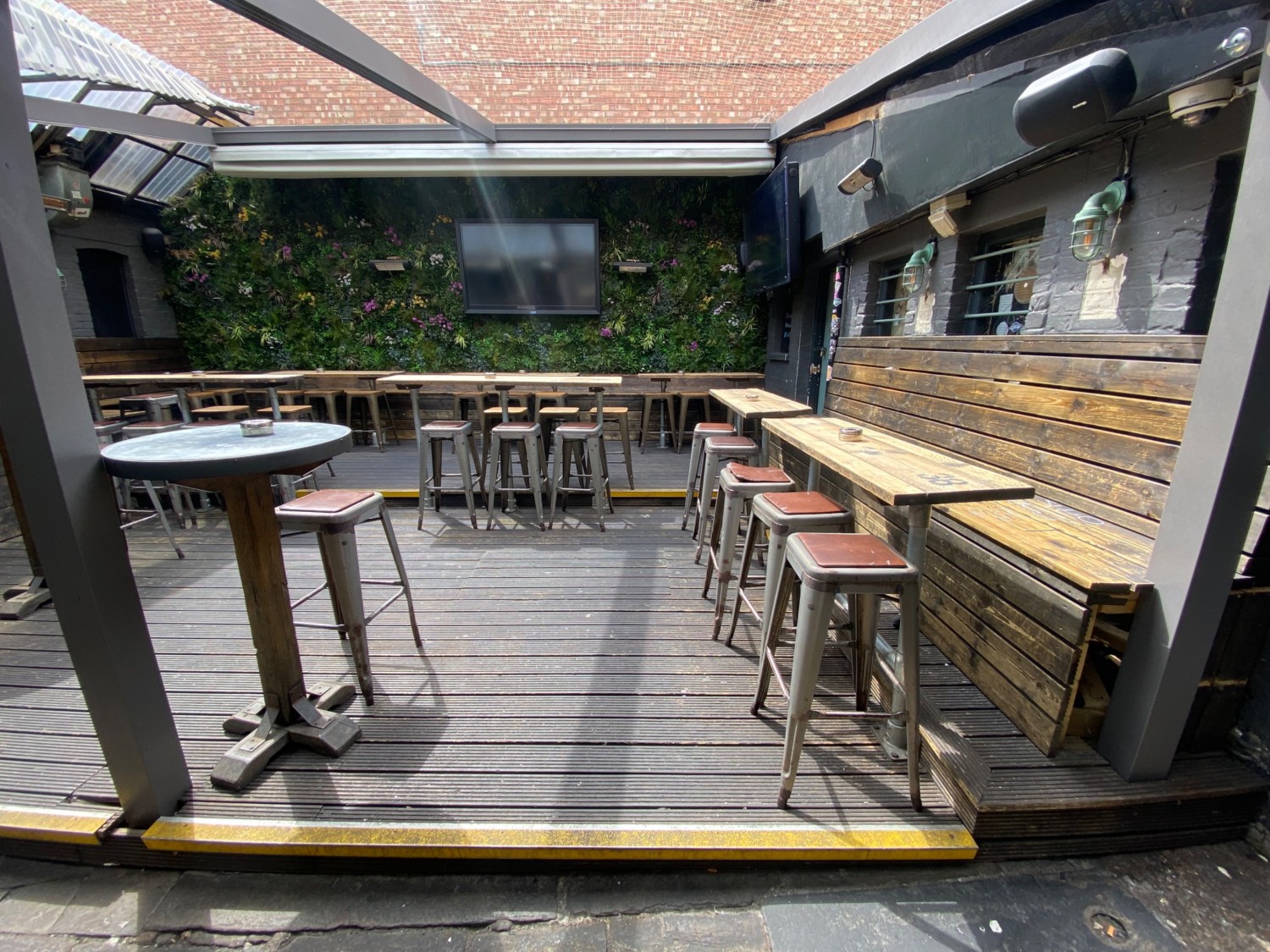View straight from entrance. Step up to seating platform. Seating along right. Row of seating before step up to further seating. High table next to pillar to left.