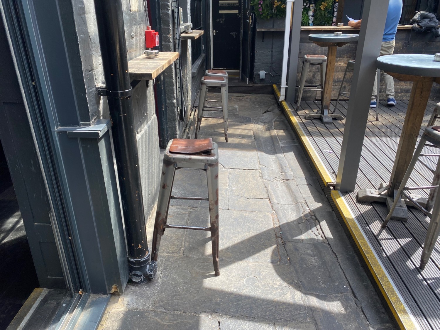 View to left of entrance. Stools along left wall. Pathway centre. Step up to seating platform to right.