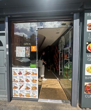 Glass door with black frame ahead. Push to open via handle on left.