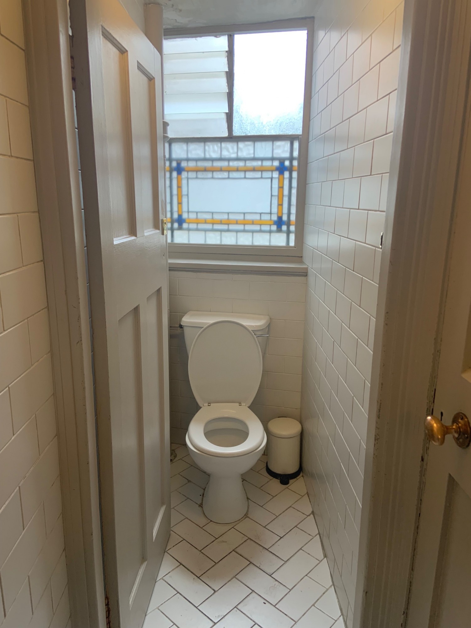 From preceding door facing right. White toilet door ahead. Push from right to open.