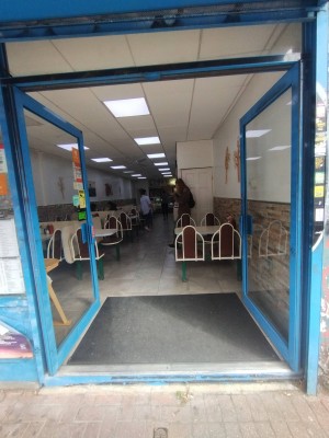 Glass doors with blue frame and blue handles in centre. Push to open.