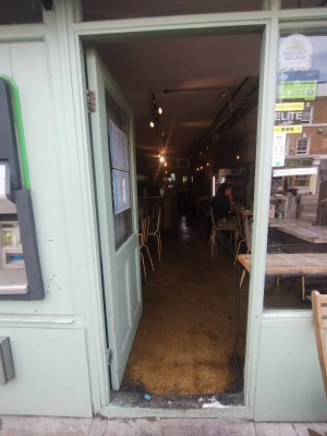 Blue wooden door with glass panel. Push open to left, handle right. Small step