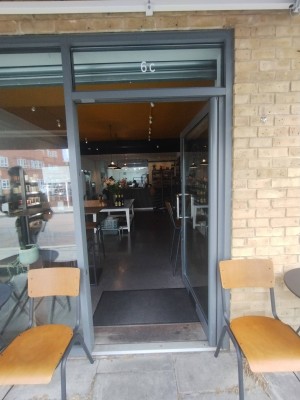 Grey framed glass door. Push silver handle on left to open.