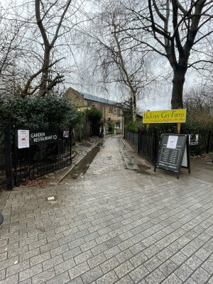Black metal gates. Push from centre to open. A-board sign on right of gate.