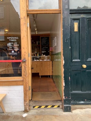 Wood-panelled glass door ahead. Push from handle on right to open.