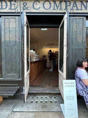 Double wooden brown and cream doors with large glass panels. Pull from middle to open.