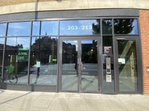 Glass doors with black frame. Push metal handles in centre to open.