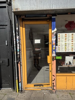 Glass door with yellow frame ahead. Push door to open from right.