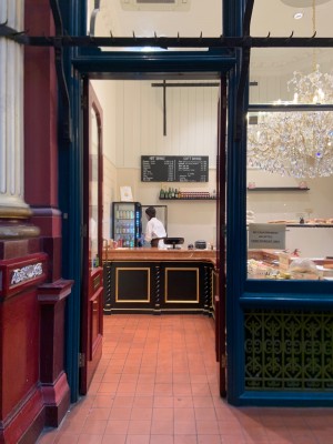 Double glass doors in red wooden frame. Push gold metal handle from centre to open.