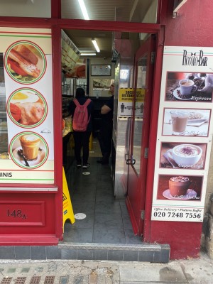 Glass door with red frame, push from left to open.