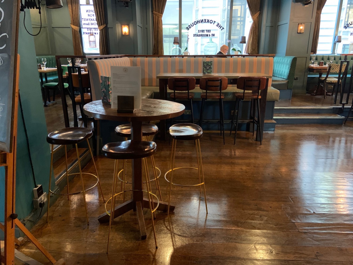 From top of stairs looking left, seating directly ahead and along back. Steps to upstairs area to back right. Pathway to bar and further seating to right.