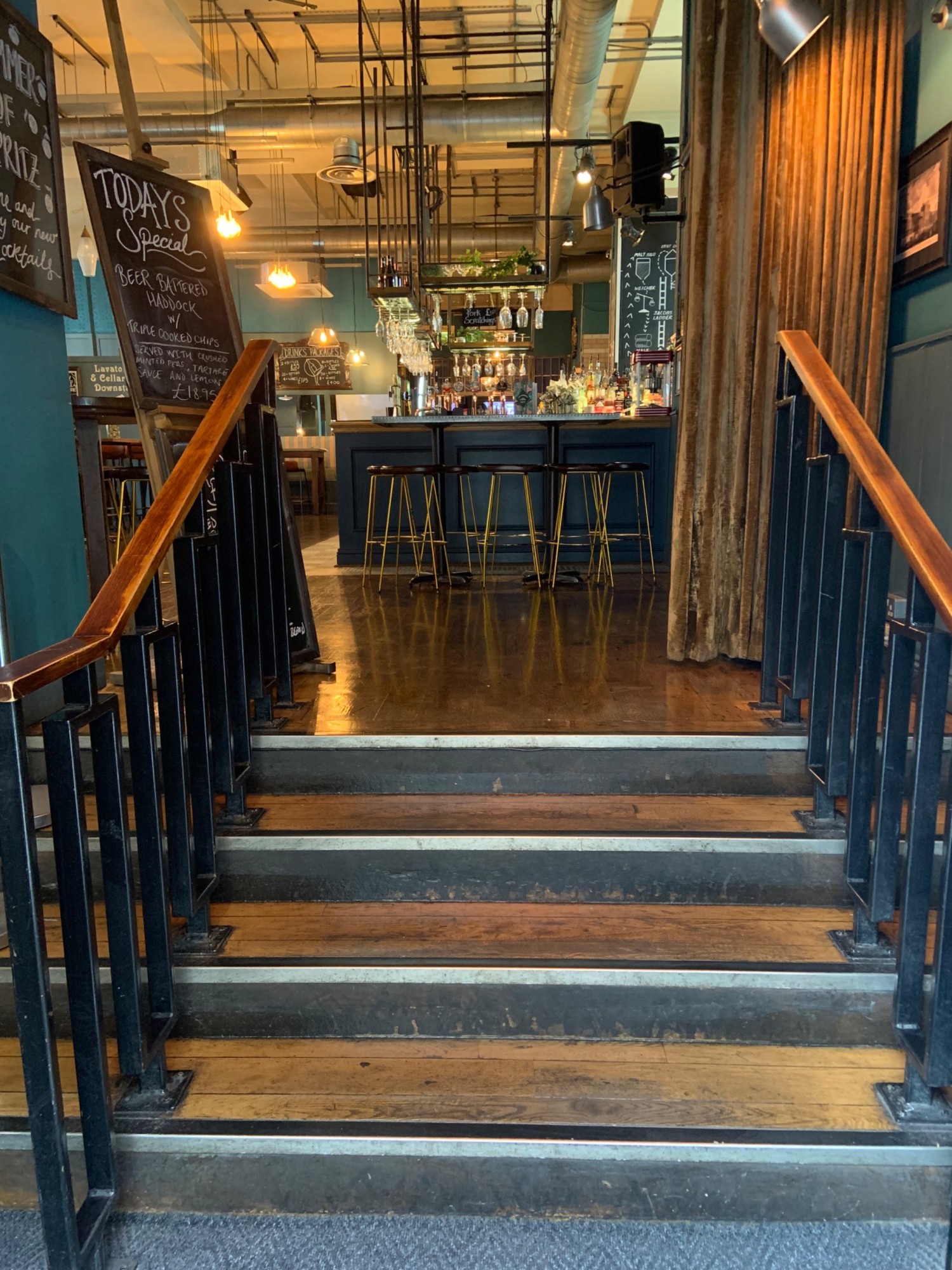 From second door looking straight, steps up to main area with handrails to each side. Curtain at top of stairs pull to open from left side.