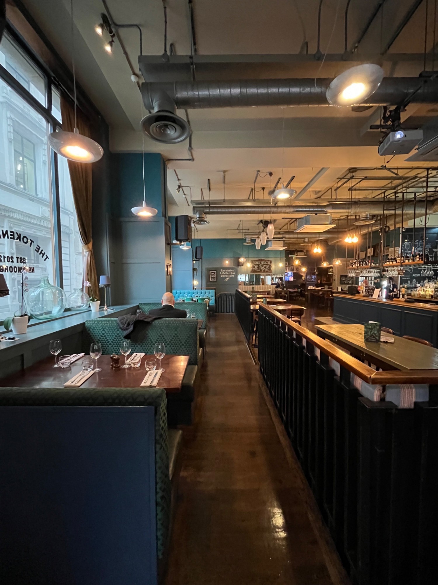 From front left corner looking ahead. Tables in the left. Pathway ahead. Downstairs area on the right.