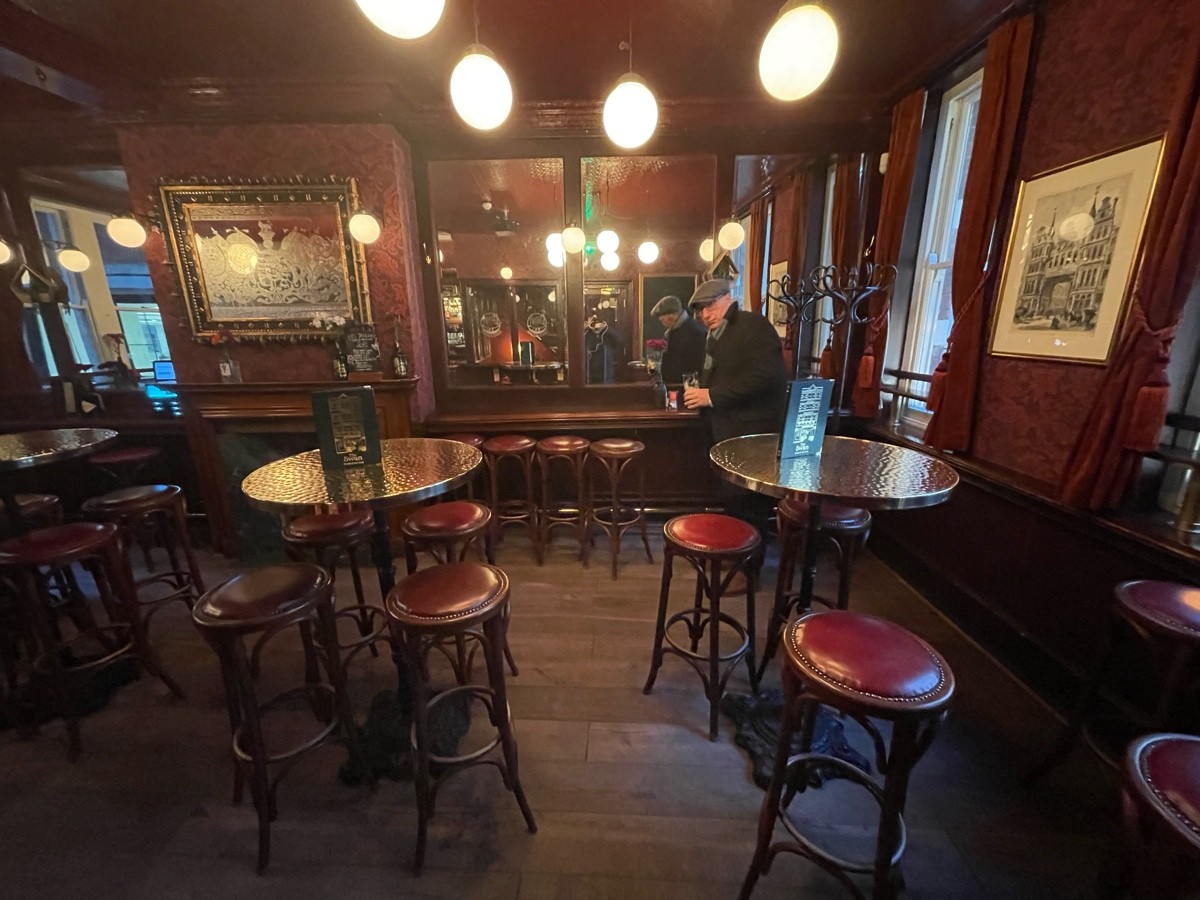 From doorway facing straight. High tables and stool in center space and along back wall.