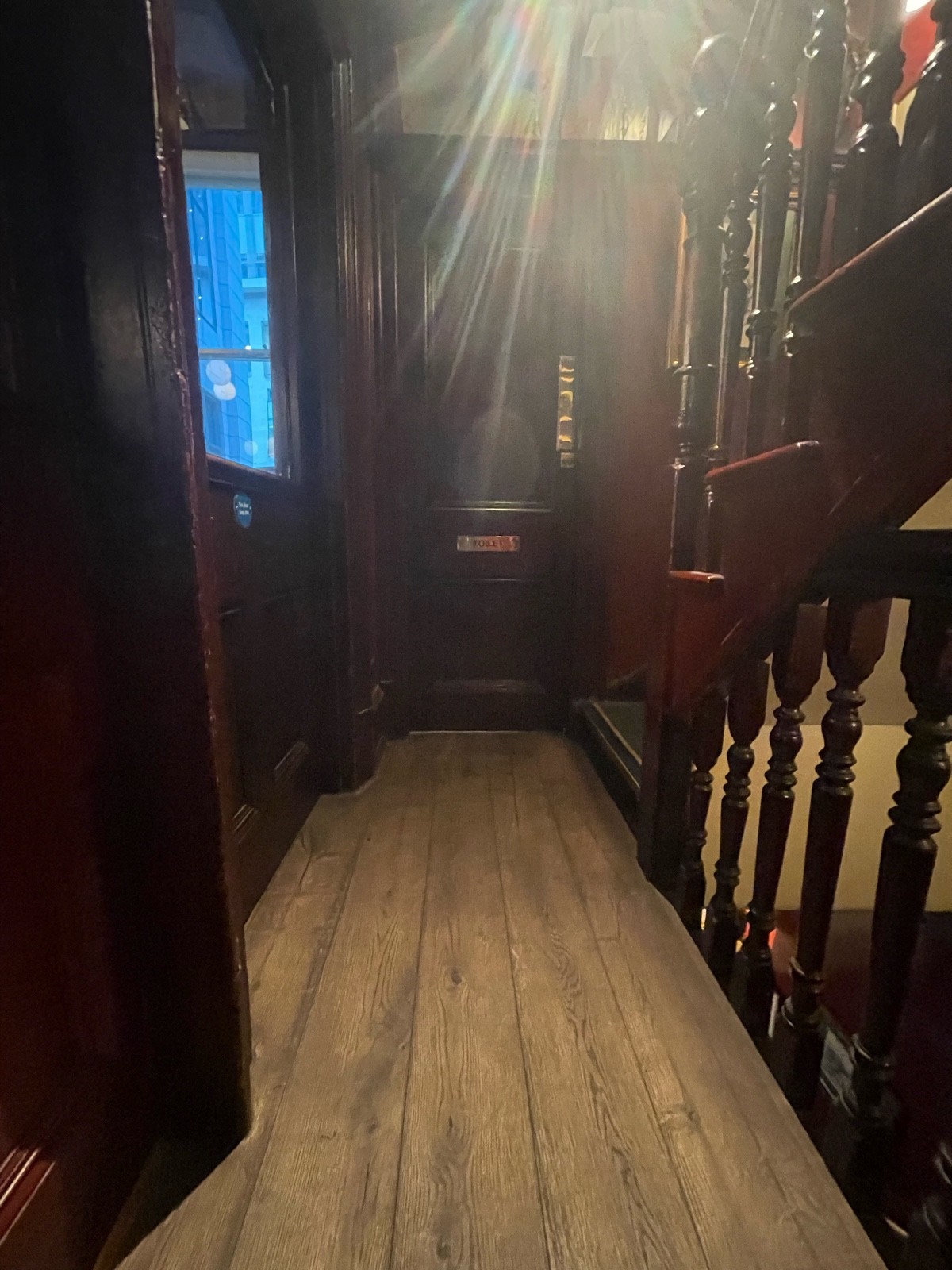 From top of stairs facing straight. Preceding door to upstairs area on left.