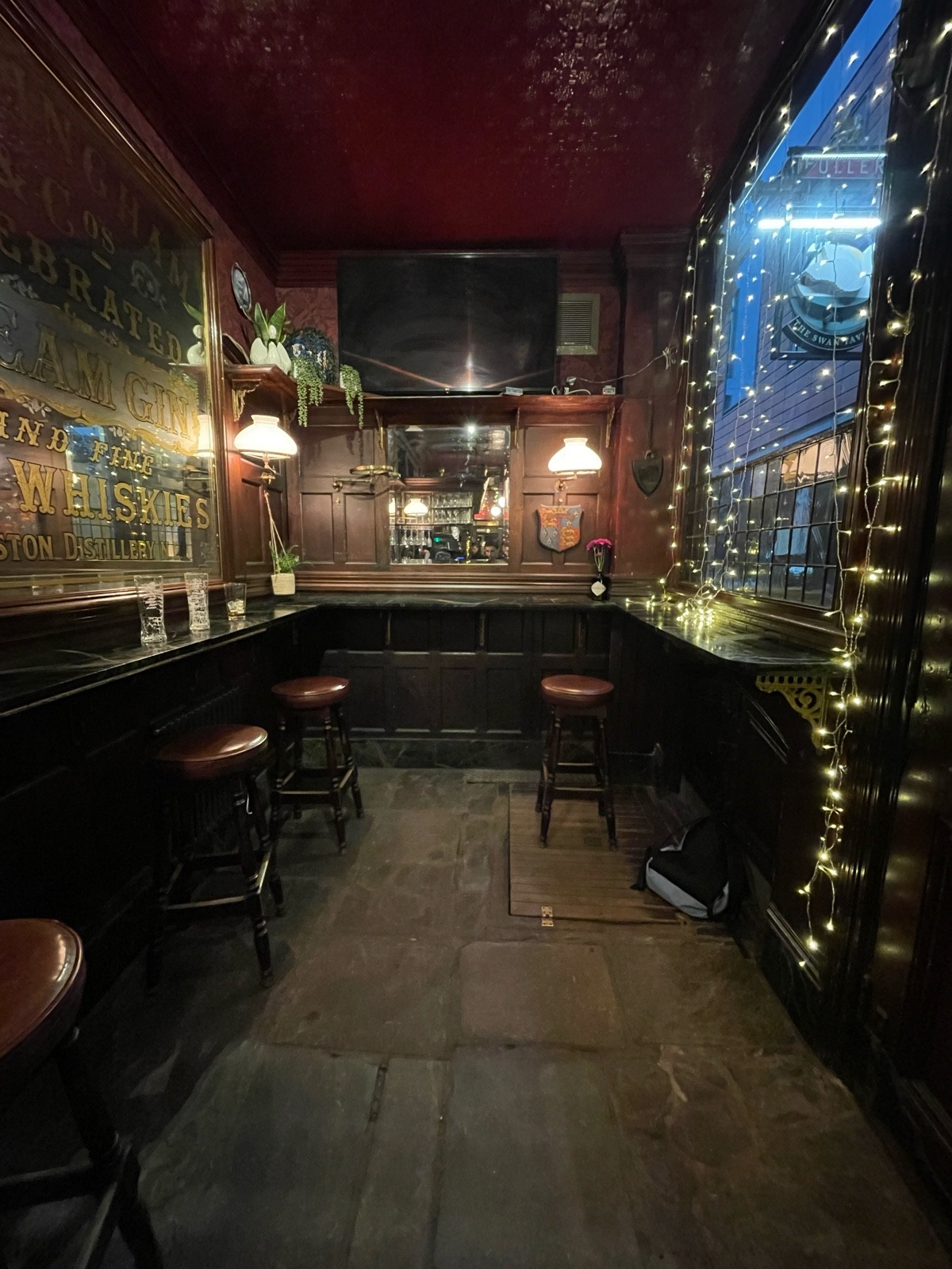 From end of bar facing straight. High table with stools along left, back and right.