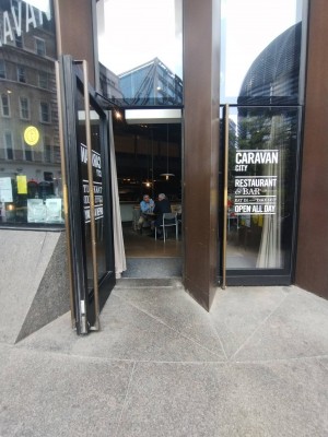 Two seperate glass doors with black frame. Pull left door open from the right. Curtain behind door.