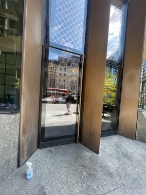 From street looking slightly left at door. Glass single door with pull handle along whole of right side of door.