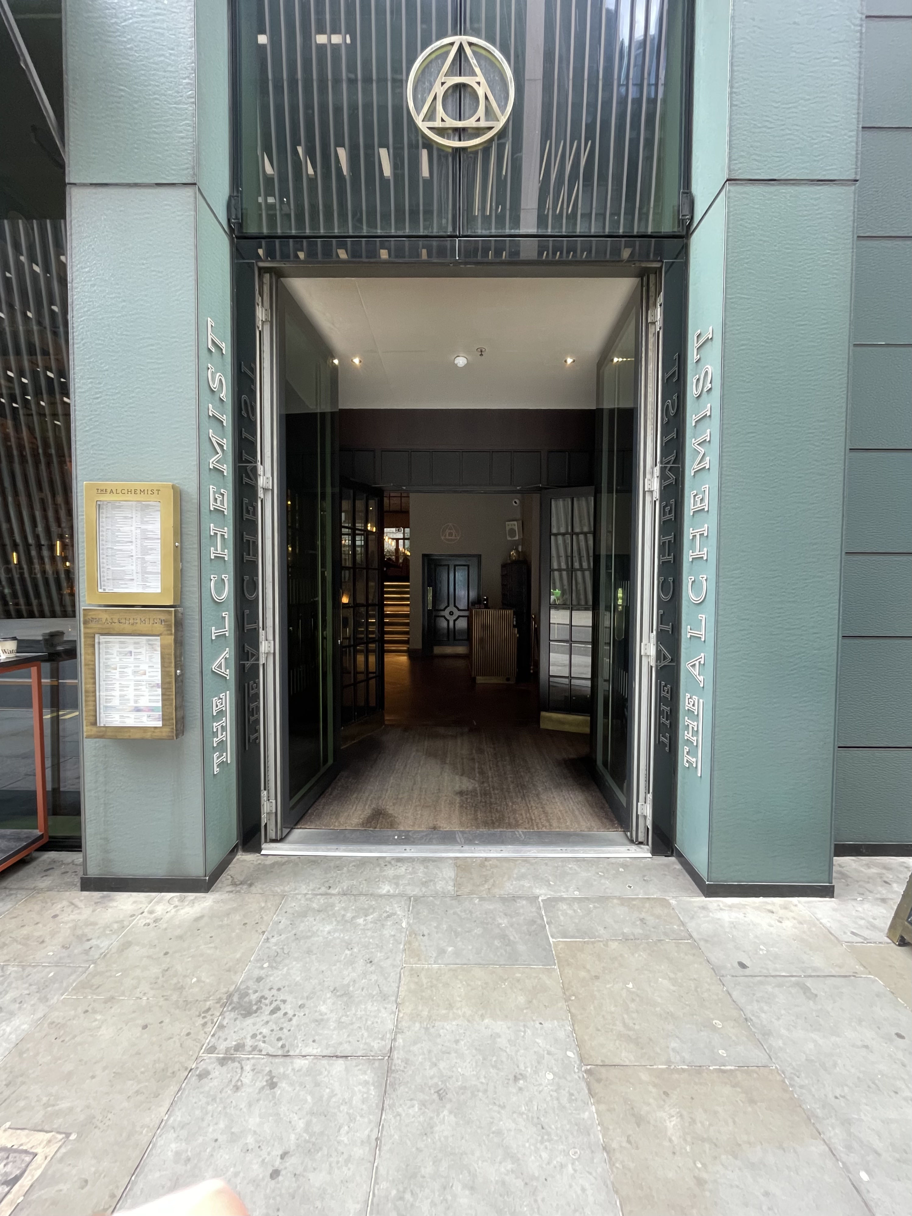 Facing entrance. First set of doors ahead. Metal framed doors. No handles, doors open from inside.