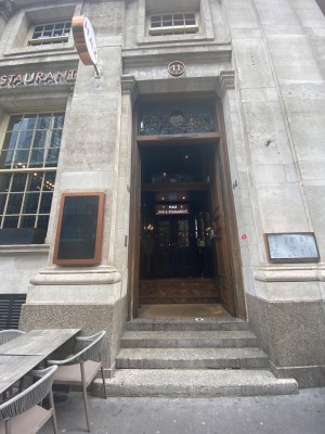Looking straight from the street. Heavy push doors preceding main doors. Handle in the middle. Push from middle of double doors.