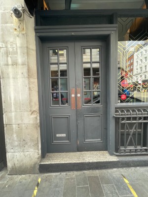 One large step leading up to grey double doors. Doors push open from the centre.
