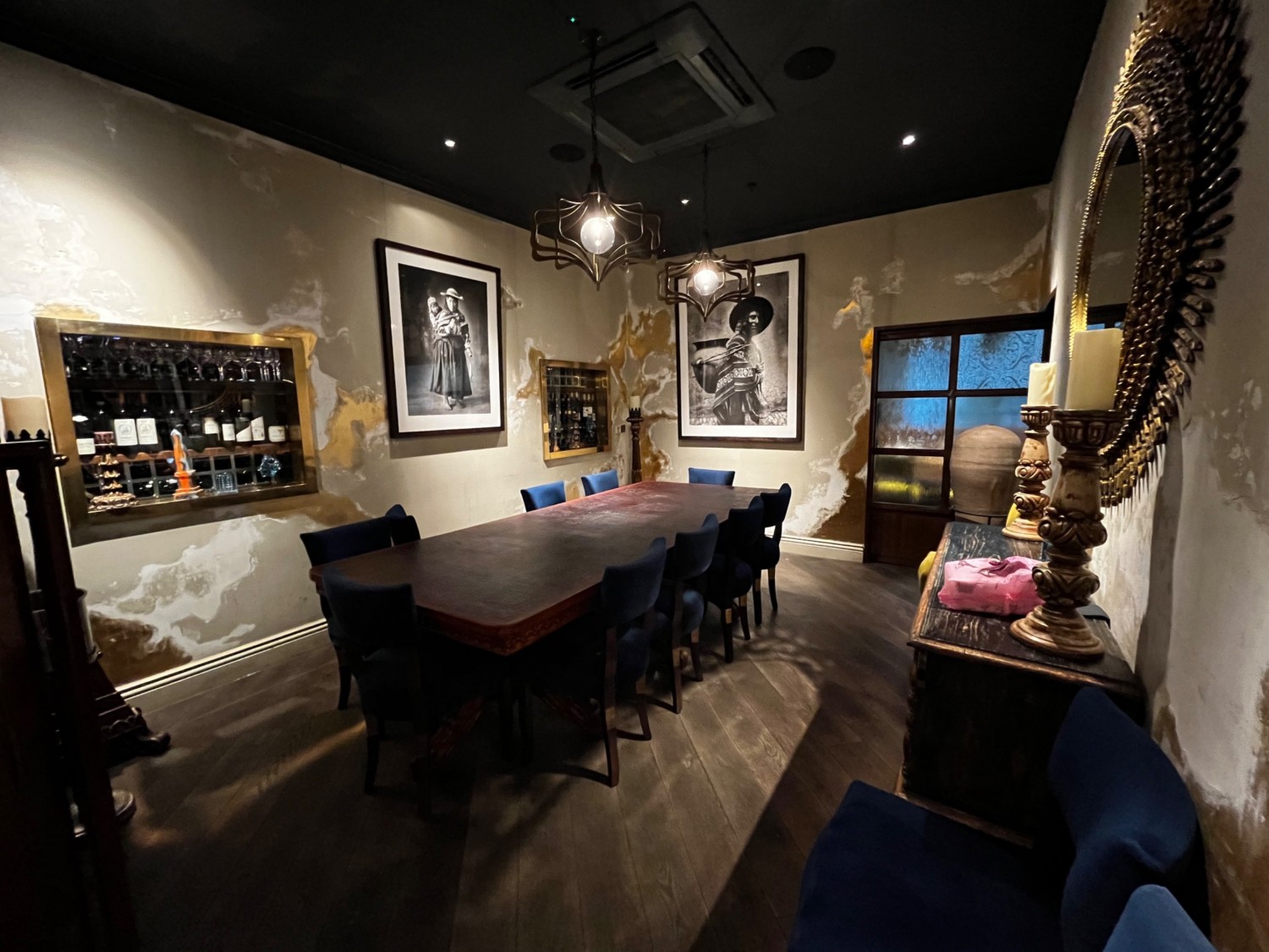 Private room in main area. Large central table with chairs all around. Wide pathways around table.