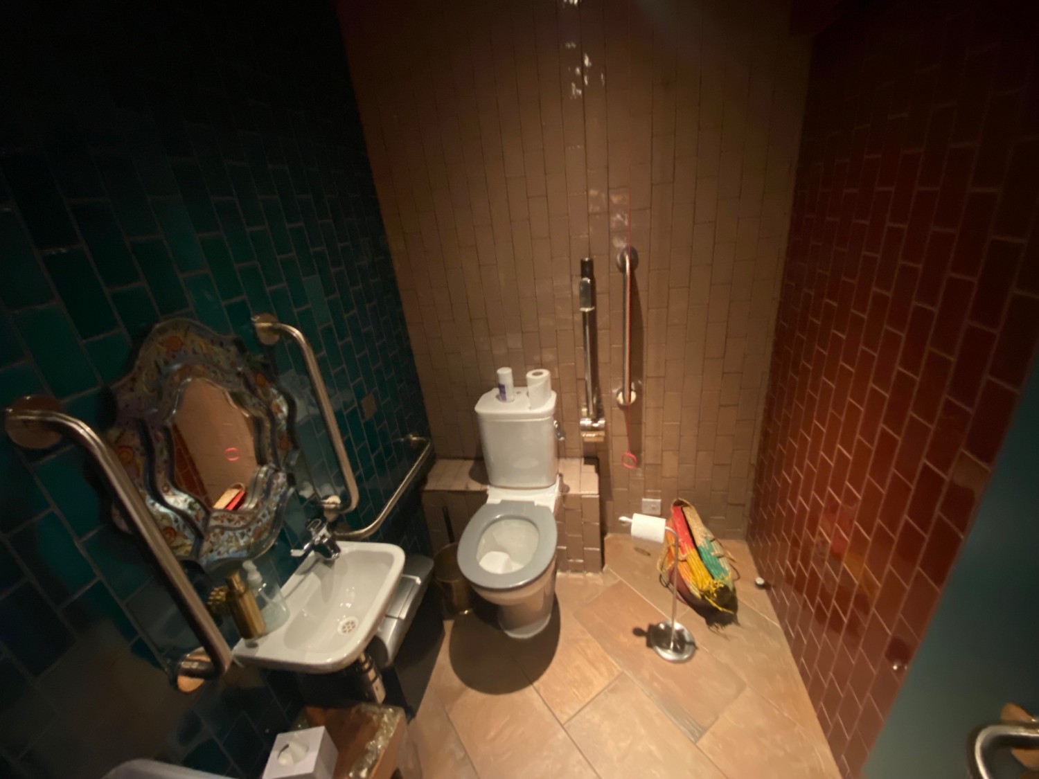 From entrance facing right. Toilet in back left corner. Emergency pull cord and grab rail to right of bathroom.