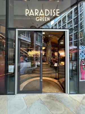 Double glass doors with black metal frame. Push vertical silver metal handles in middle to open.