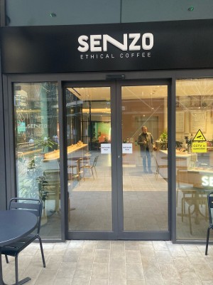 Glass doors with grey frame ahead. Doors slide to open from center automatically.