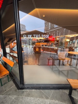 Glass door. Slide black metal edge along left to open.