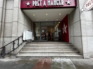 From street, facing venue. Stairs ahead. Doorway at back. Platform left along left.