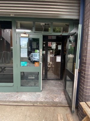 Preceding glass doors with green wooden frames. Pull silver handles in middle to open.