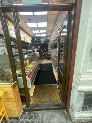 Brown-framed glass push door from left. One step before door.