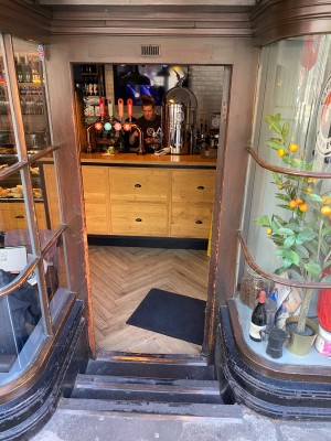 Dark wooden framed glass push door (handle on left). Three steps down to go through door.
