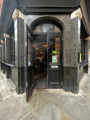 Glass door with black frame. Pull silver, metal handle on right to open.